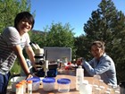 Two researchers setting up their makeshift lab on a picnic table.