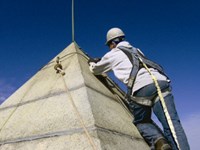 A worker scaling the top of the Bunker Hill Monument Pyramidion.