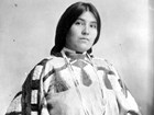 Black and white portrait of young indigenous woman in beaded dress and belt