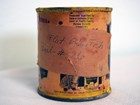 Cylindrical metal can with yellow paint remnants and note that reads “Flat Blue Fish, Panel - #26.”