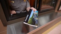 A ranger hands the viewer a Pictured Rocks unigrid