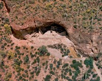Aerial shot of the lower cliff dwelling, surrounded by saguaro cactus and green desert foliage.