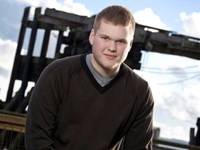 A young man near the skeleton of a ship.
