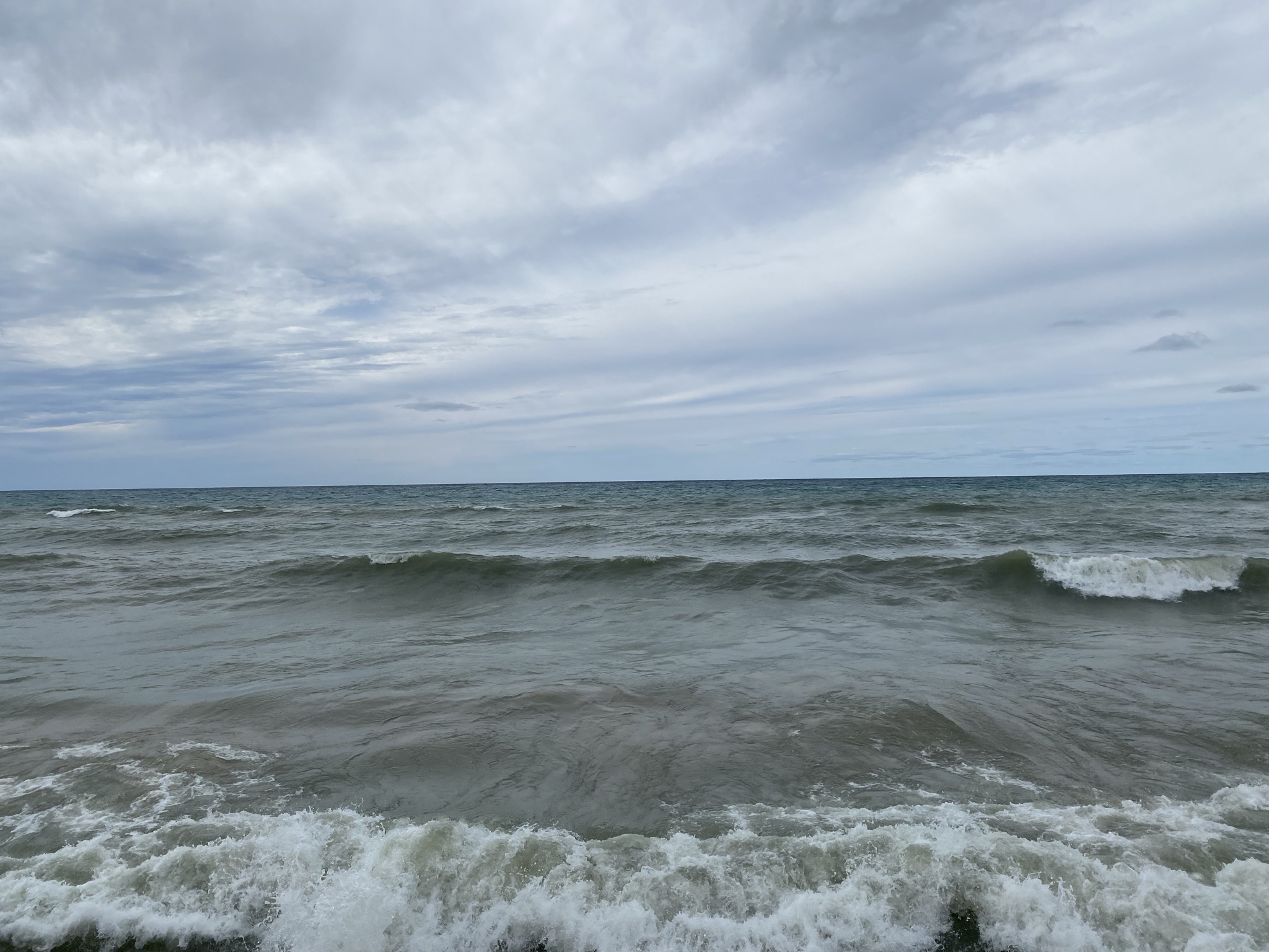 Lake Michigan view from the shoreline. Gray day with waves rolling in.