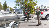 a ranger power washes a boat on a trailer