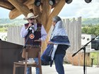 a man wrapped in a blanket looking at a man talking into a microphone