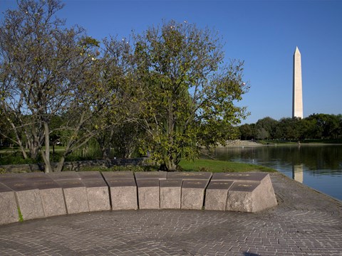 Low stone blocks arranged in an arc with the Washington Monument in the background