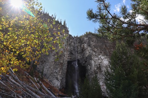 A thin waterfall cascades down a rocky cliff.