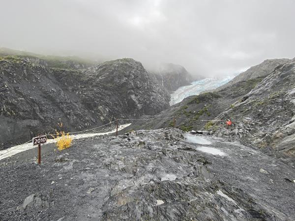A on the left of the image says 2010. Behind it a glacier is in the center between two mountains.