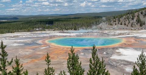 A large, colorful hot spring as viewed from above.