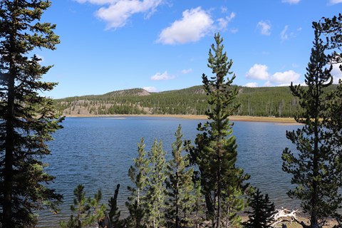 A lake surrounded by rolling hills and forests.