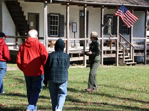 A park ranger speaking to visitors outside of a historic home