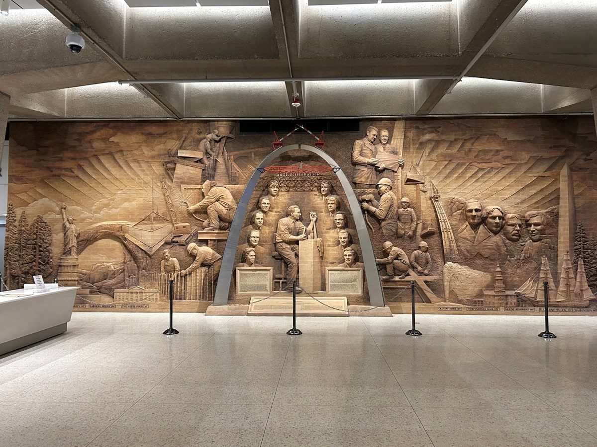 A steel arch with several carved figures inside and around it