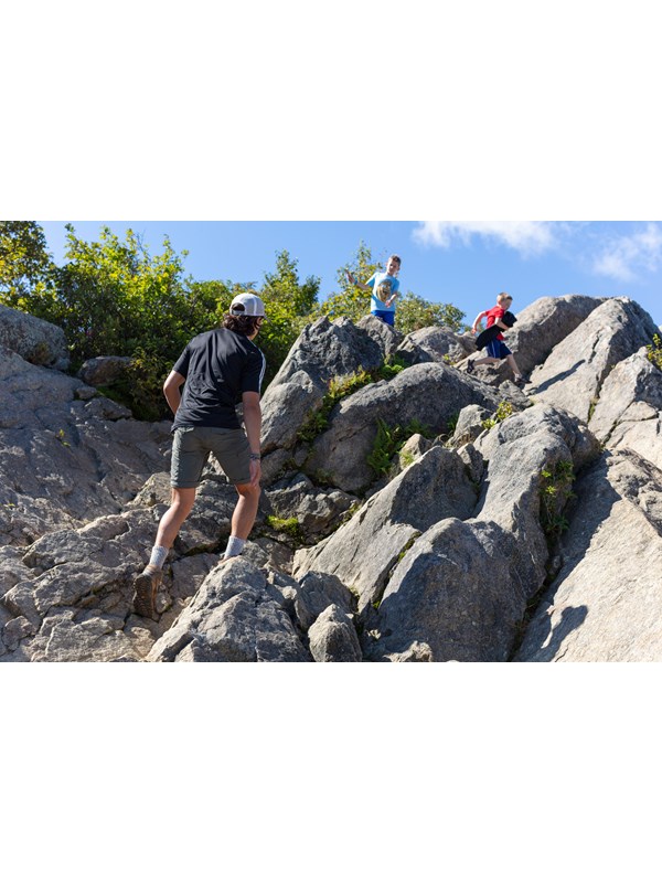 Hikers traverse large boulders at the summit of Marys Rock