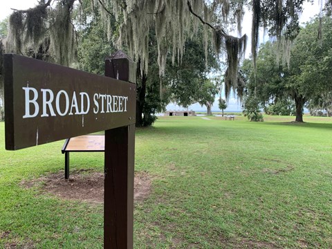 A sign with text "Broad Street" with a grass path in the background