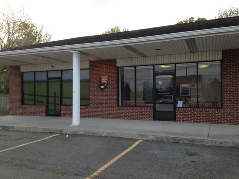 A national park visitor center occupies a store front in a brick commercial building.