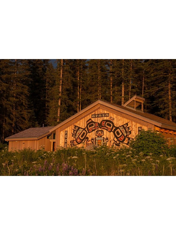 a large building with traditional alaska native carvings on the front at sunset