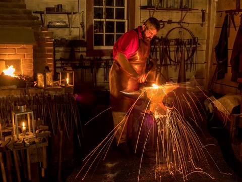 A blacksmith working inside the Blacksmith Shop at Fort Vancouver.