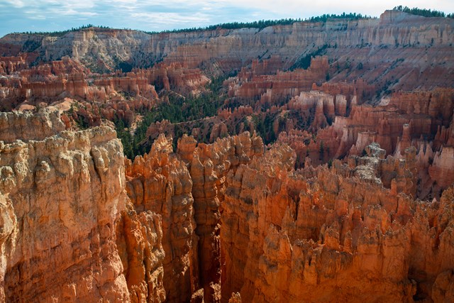 Red and white rock fins stand among distant spires and forested landscape