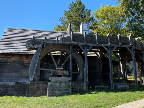 A wooden building with two massive wooden wheels.