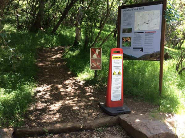 a trailhead sign a burned area warning sign are located at the beginning of a trail.