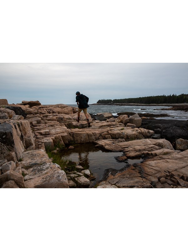 Person walking along rocks on a coastline