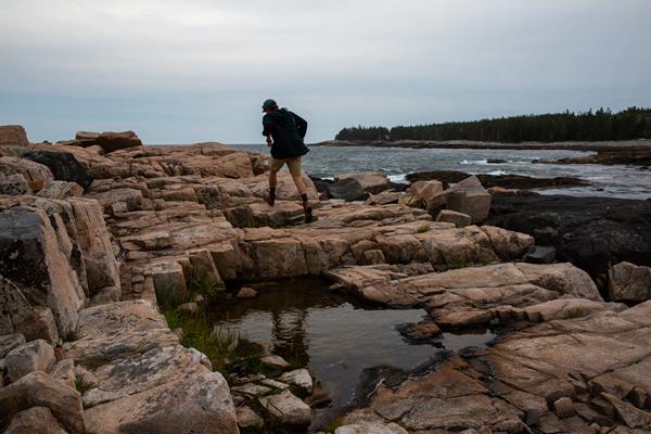 Person walking along rocks on a coastline