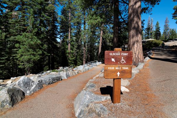 Wooden trail sign at a fork of two trails.