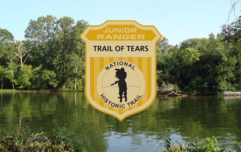 A junior ranger badge over an image of a flat green river with vegetated river banks.