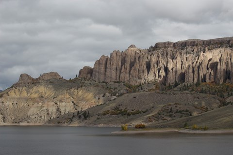 Geologic formations on the side of a mesa in front of a body of water