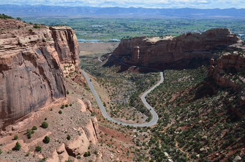 Looking down at road as it curls into and out of red rock canyon.