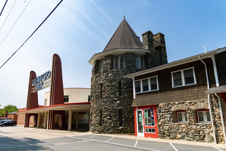 A stone turret with three floors and a pointy, shingled roof.
