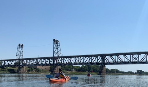 River ranger kayaking on the river near the Meridian Bridge on the Missouri River.