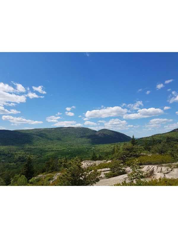 view of two mountains in the distance from the summit of another mountain