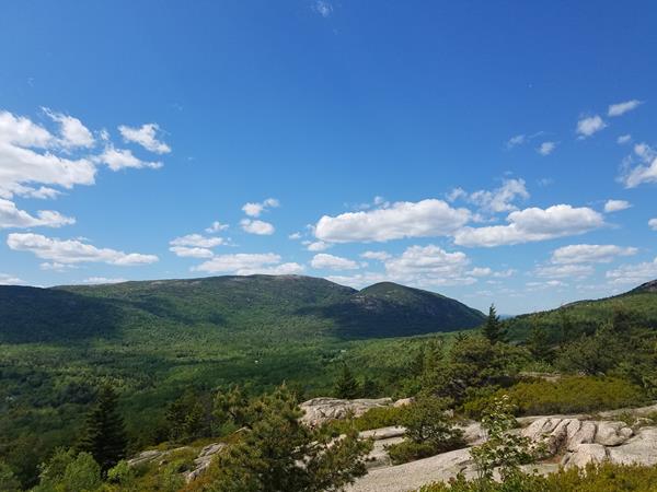 view of two mountains in the distance from the summit of another mountain