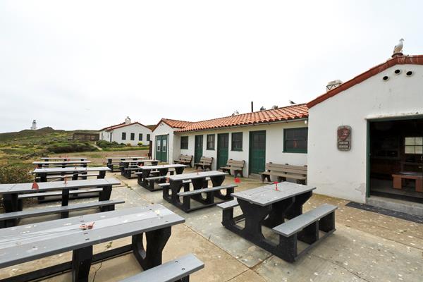 picnic tables outside stucco building with red tile roof
