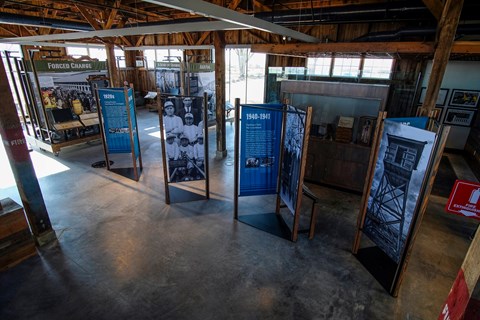 The rustic interior of the visitor center with upright panel displays on park history.