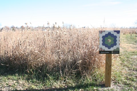 Sign with a quilt block along the trail in the prairie