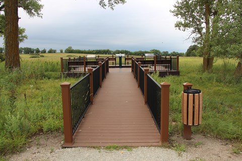 A wheelchair accessible ramp leads from the trail up to a platform that overlooks the prairie.
