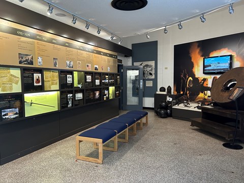 Museum with information panels on the left and cannon artifacts on the left.