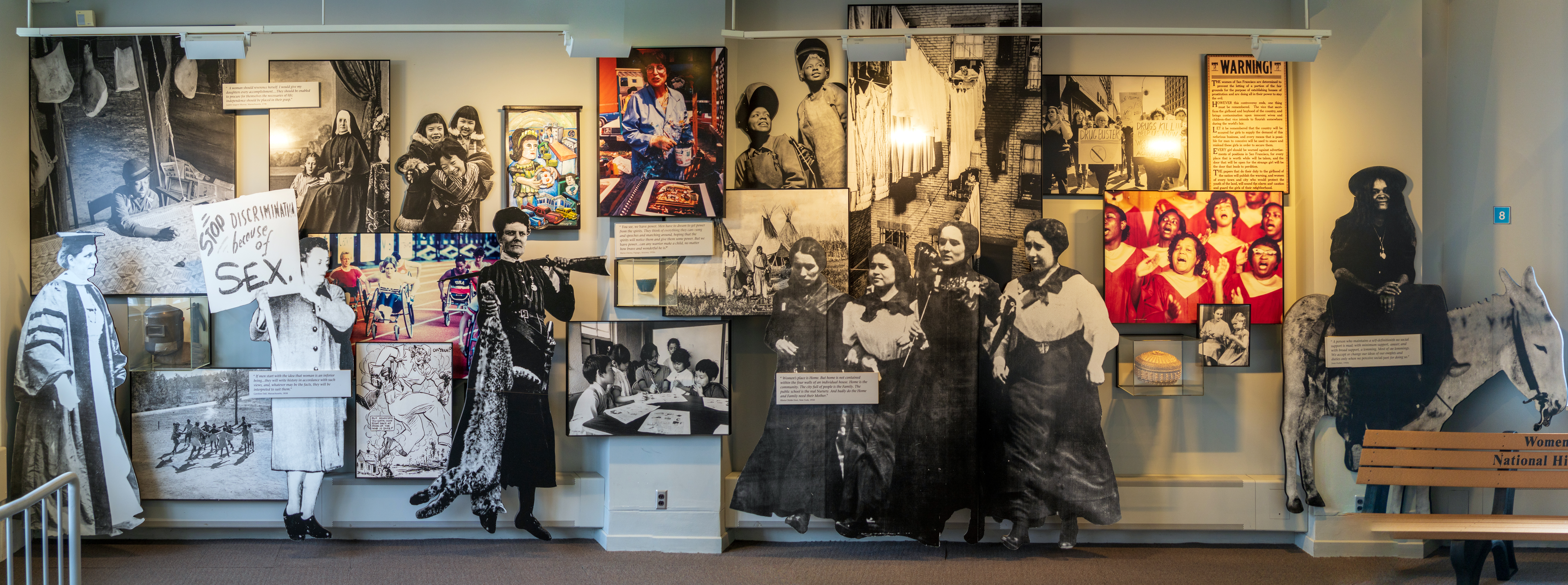 A wall of various photos in an exhibit.