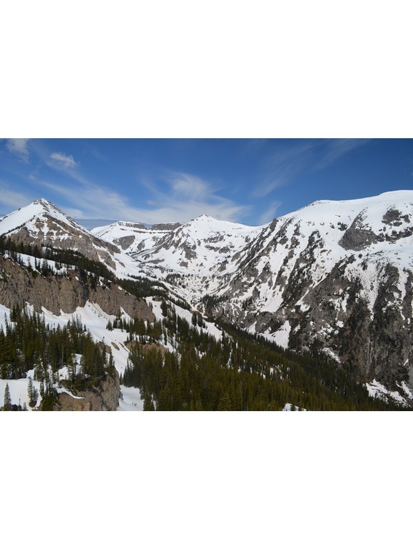 A mountainous canyon covered in patchy snow.