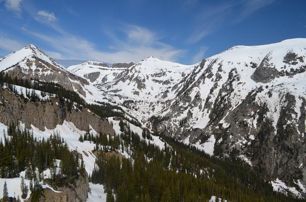 A mountainous canyon covered in patchy snow.