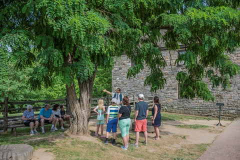 A living history interpreter shows visitors what it would have been like to run the gristmill.