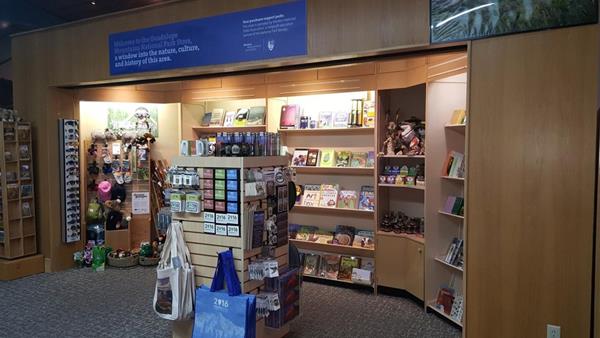 A retail space with books and other items for purchase shown on shelves and racks