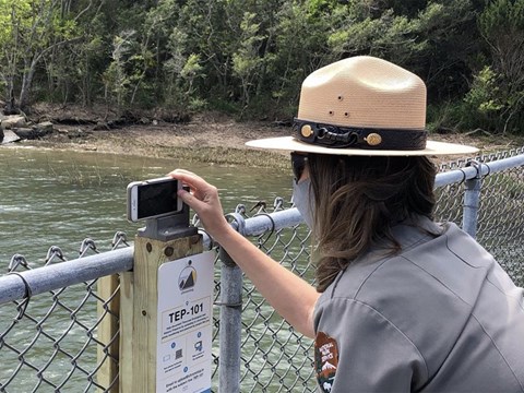 a ranger takes a photo on the dock