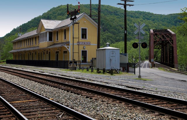yellow railroad depot and train tracks
