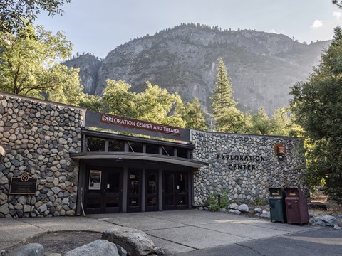A building with glass double doors and river rock walls surrounding both sides