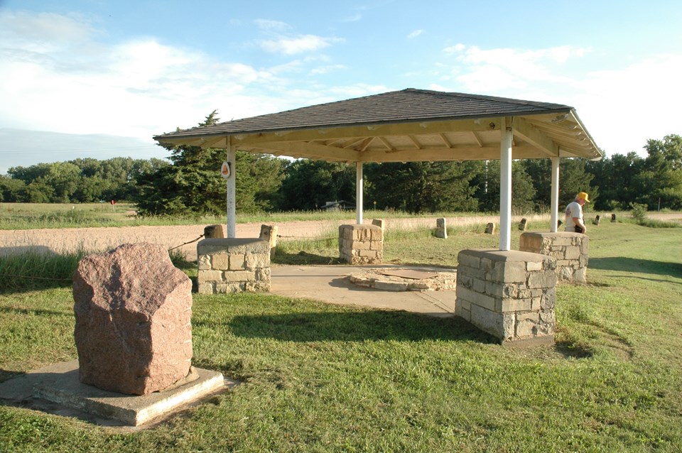 A granite marker and a ground well covered with a portico