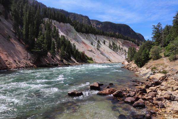 A river flows through a canyon with pale, sloping walls.
